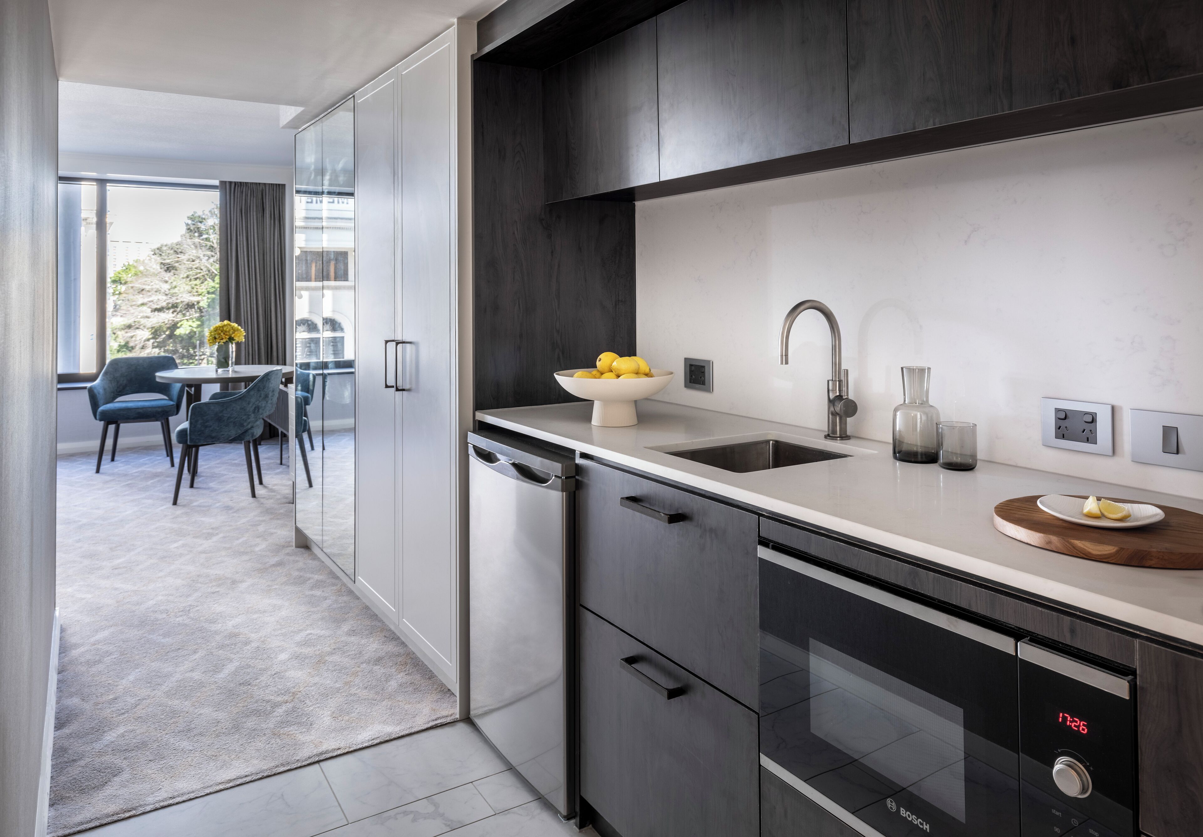 A modern kitchen with a Bosch dishwasher, a sink, and a dining area with a table and chairs.