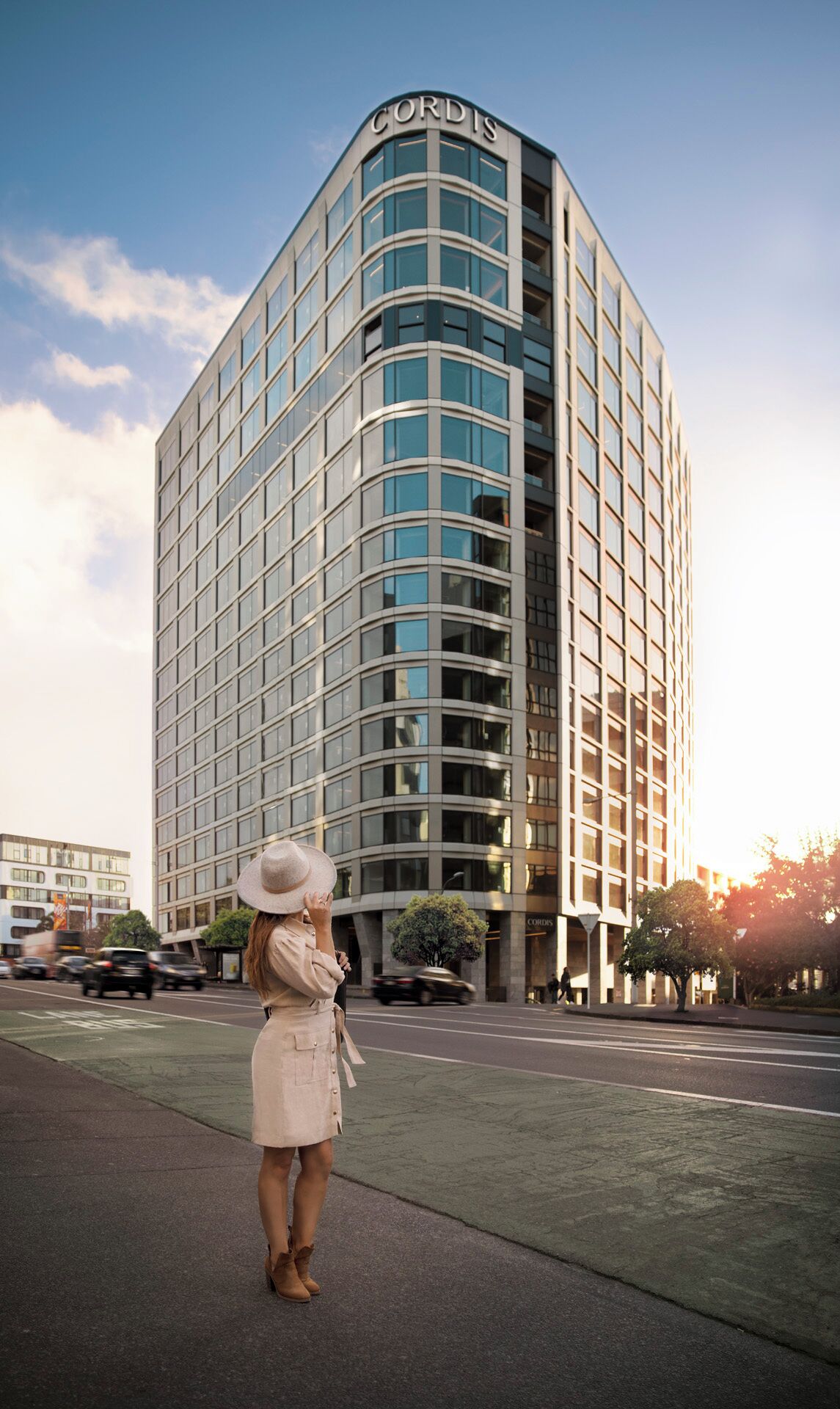 A modern hotel with a curved facade, large windows, and a prominent 'CORDIS' sign.