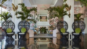 A spacious lobby with a traditional Asian-inspired decor, featuring a central fire pit, seating area with intricately designed chairs, and lush tropical plants. - The Colony Hotel Palm Beach (Palm Beach)