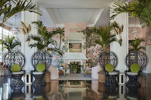 Experience the serene ambiance of our elegant lobby, featuring a central seating area with intricately designed chairs and a traditional Asian-style fireplace.