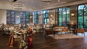 A spacious dining area with multiple tables, chairs, and a central seating area. - Renaissance Austin Arboretum Domain Hotel (Austin)