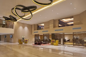 A spacious lobby with a modern chandelier, seating area, and a reception desk. - Holiday Inn Golden Mile Hong Kong by IHG (Kowloon)