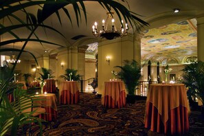 A hotel lobby with round tables covered in red tablecloths, a chandelier, and a patterned carpet. - Palmer House a Hilton Hotel (Chicago)