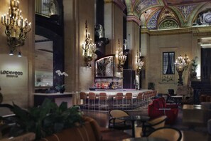 A grand lobby with ornate chandeliers, a bar area, and a seating arrangement. - Palmer House a Hilton Hotel (Chicago)