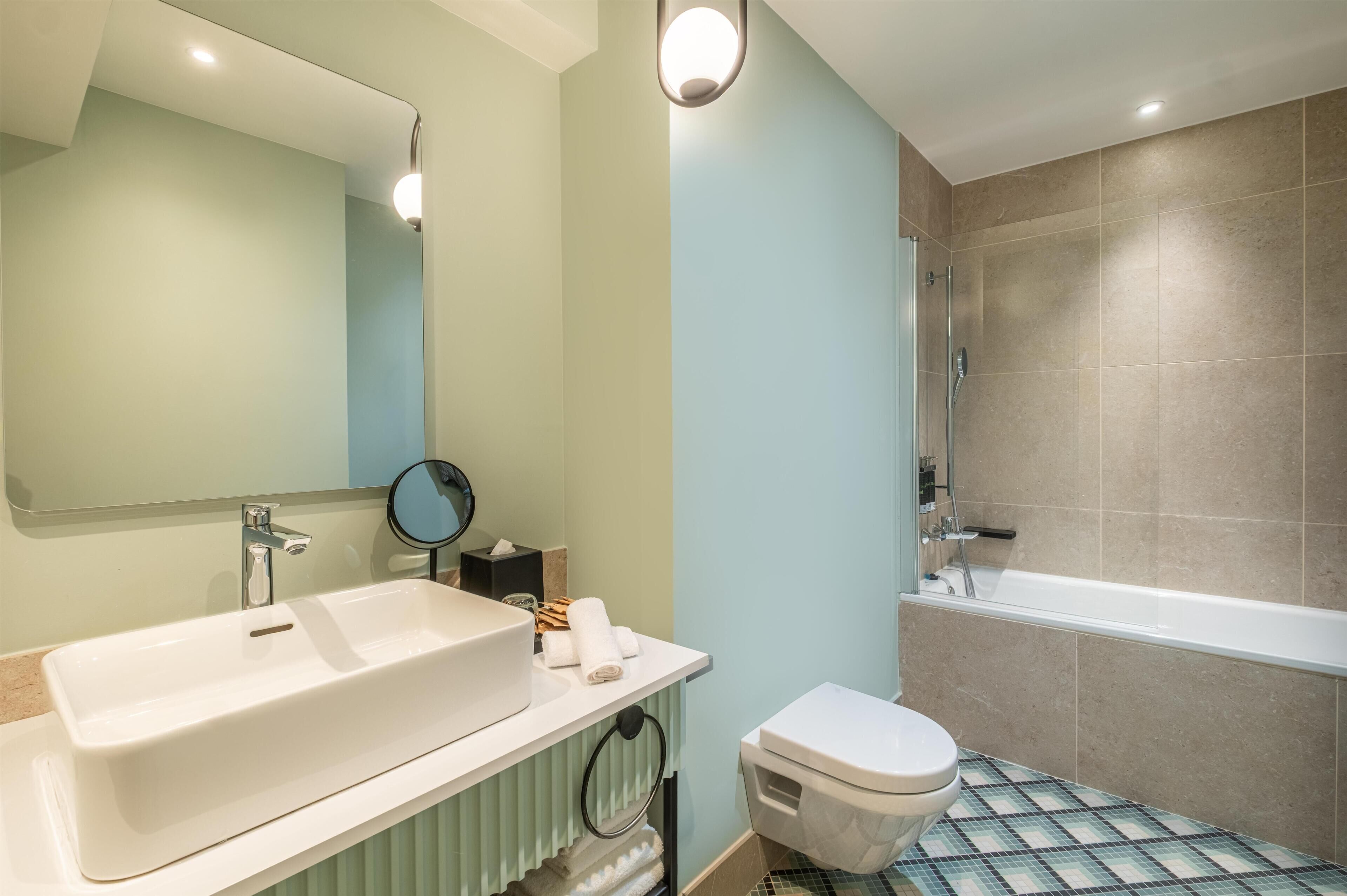 A bathroom with a sink, toilet, and bathtub.
