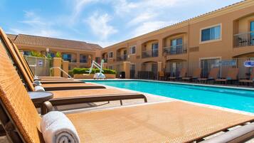 Relax by the pool surrounded by comfortable lounge chairs and a secure fence.