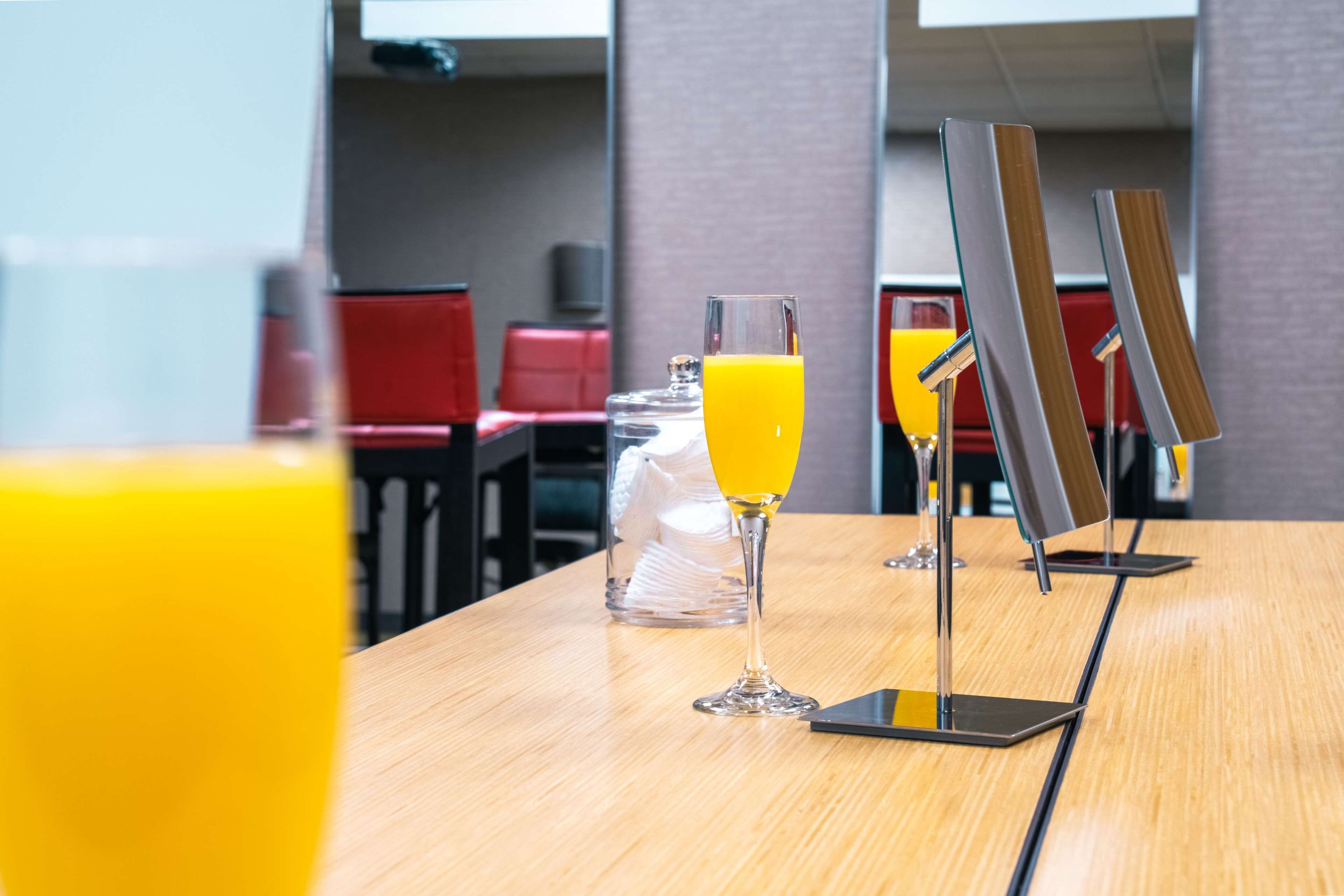 A breakfast table with a glass of orange juice, a glass of orange juice, and a glass of orange juice.