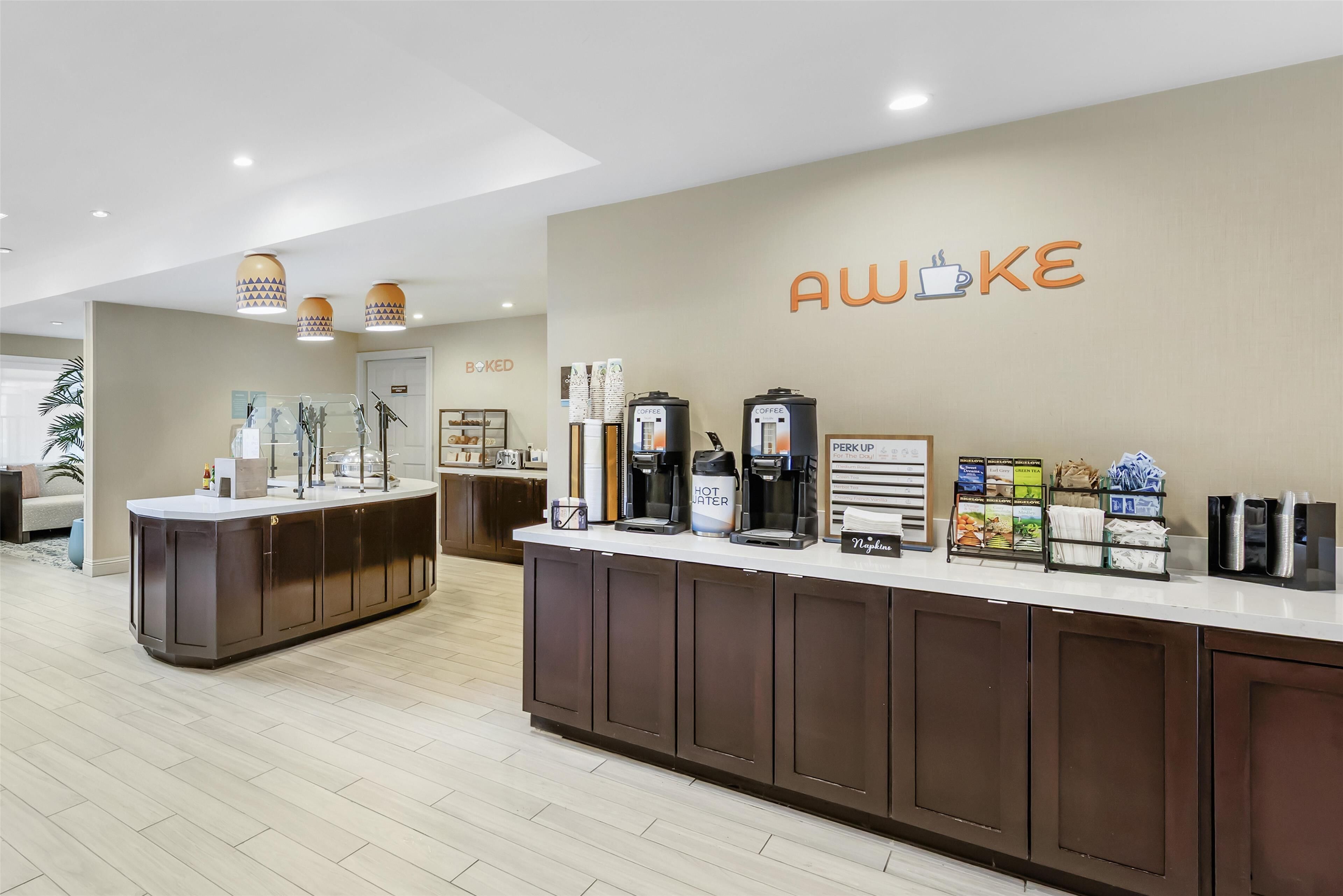 Una moderna estación de café con mostrador, máquinas de café y un letrero que dice "Awoke".