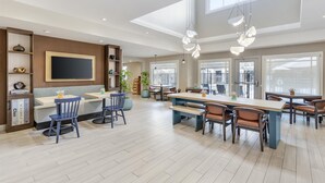 A spacious dining area with high ceilings, large windows, and modern pendant lighting. - Sonesta ES Suites Chatsworth (Chatsworth)