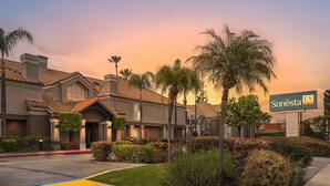 A Sonesta hotel with a landscaped entrance, palm trees, and a clear sky. - Sonesta ES Suites Chatsworth (Chatsworth)