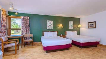 A room with two beds, a desk, and a chair.