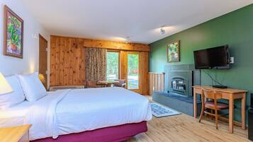 Un dormitorio con cama, escritorio, televisión y chimenea.