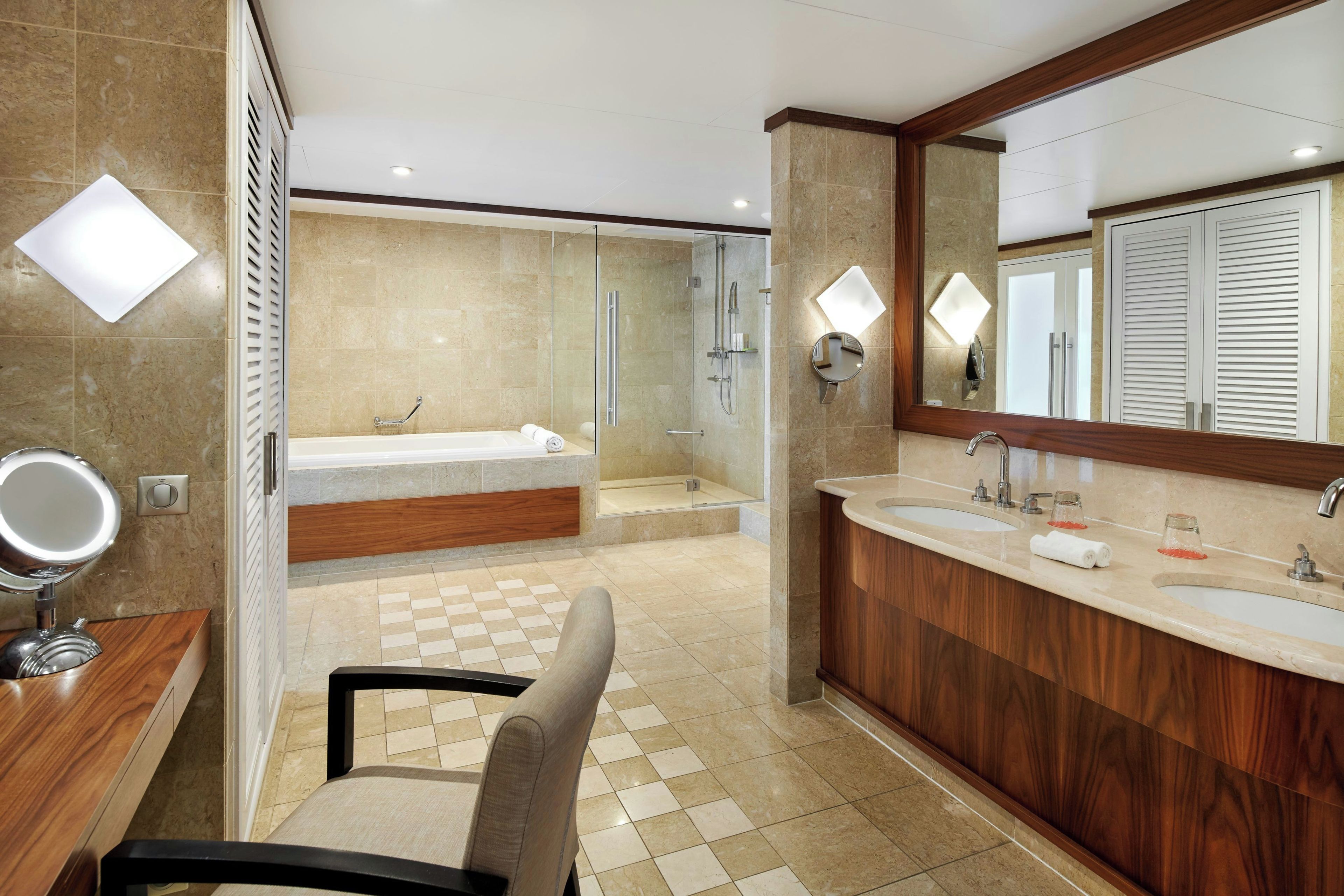 A modern bathroom with a large mirror, a bathtub, a shower area, and a vanity with a sink.