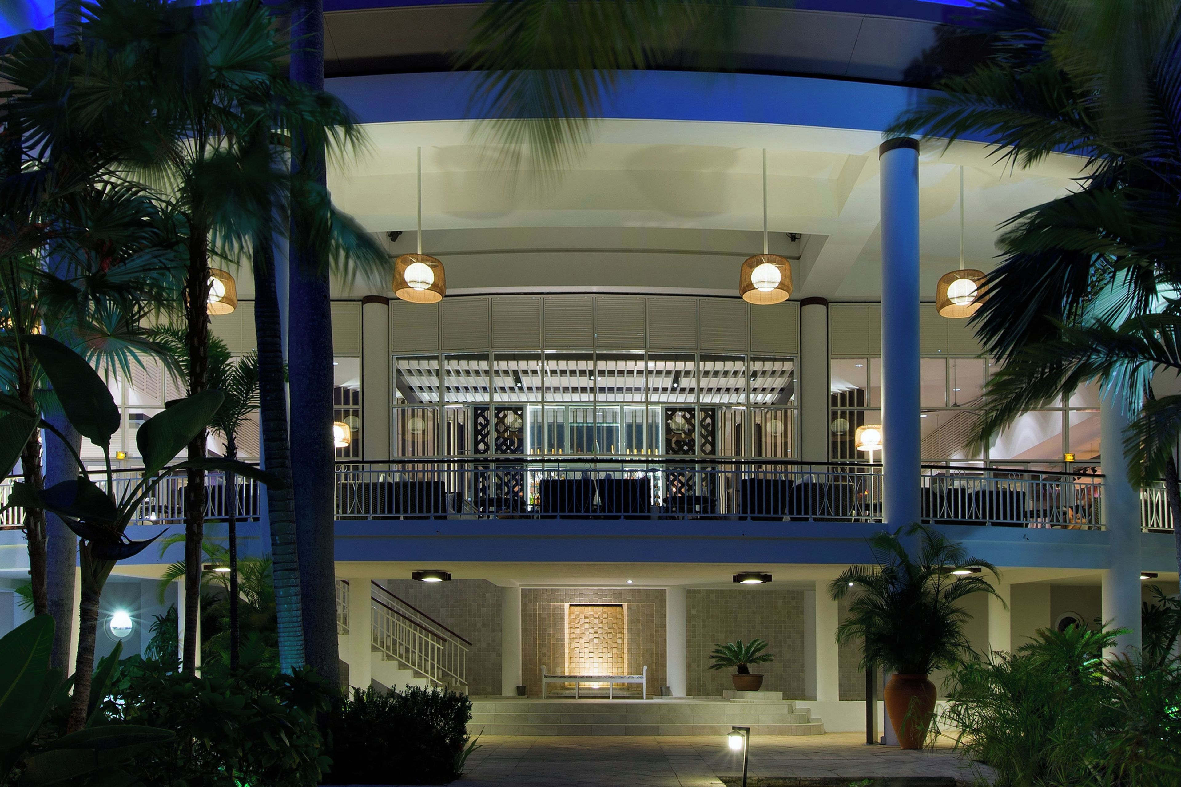 A hotel with a two-story structure, a balcony with railings, and a staircase leading to the upper level.