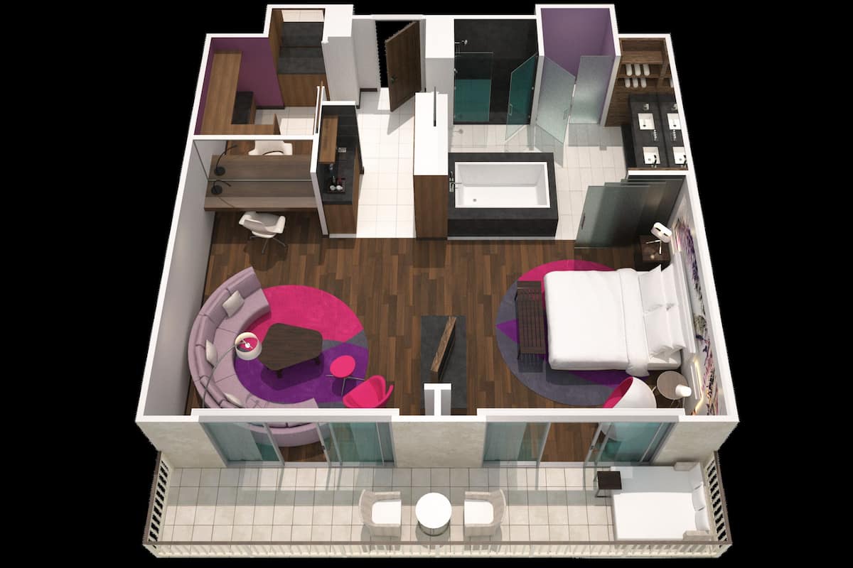 Una habitación de hotel moderna con una cama grande, un área de descanso con sofá y una mesa de centro, un baño separado y un pequeño balcón con asientos.