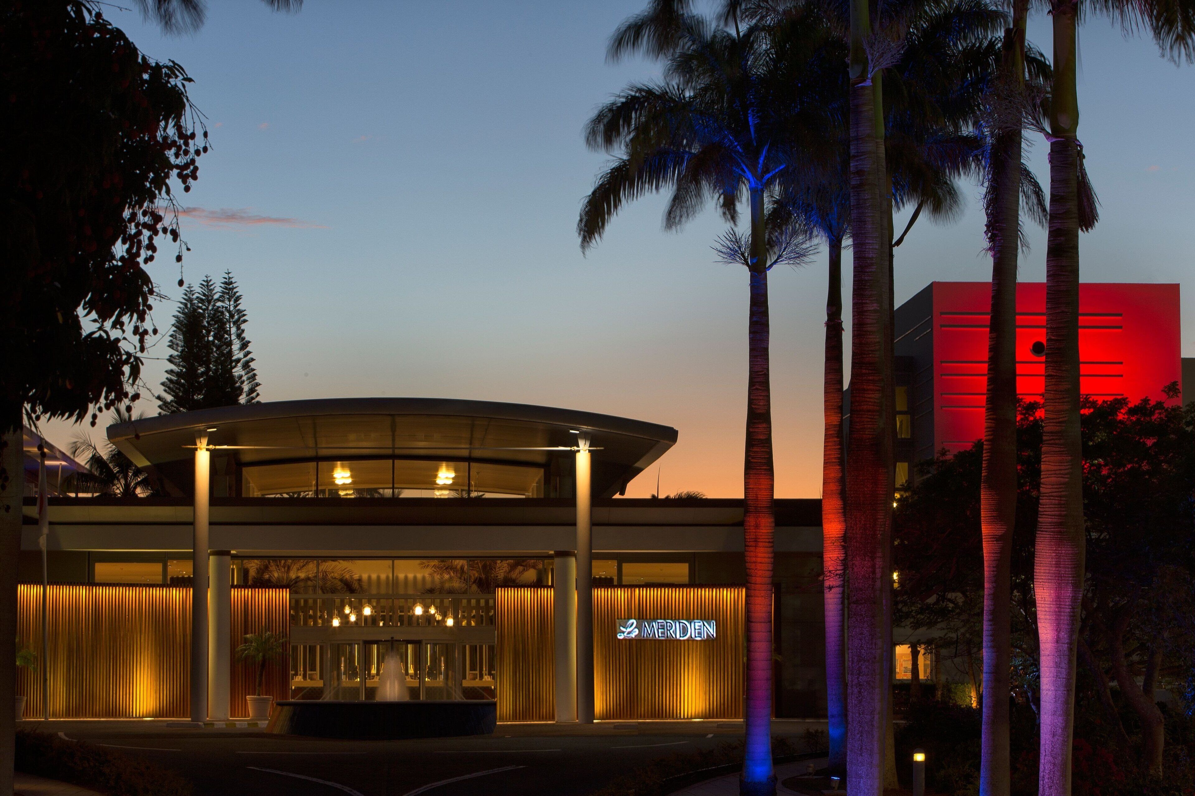 A modern hotel with a curved facade, a prominent entrance, and a visible sign reading "MERIDEN".