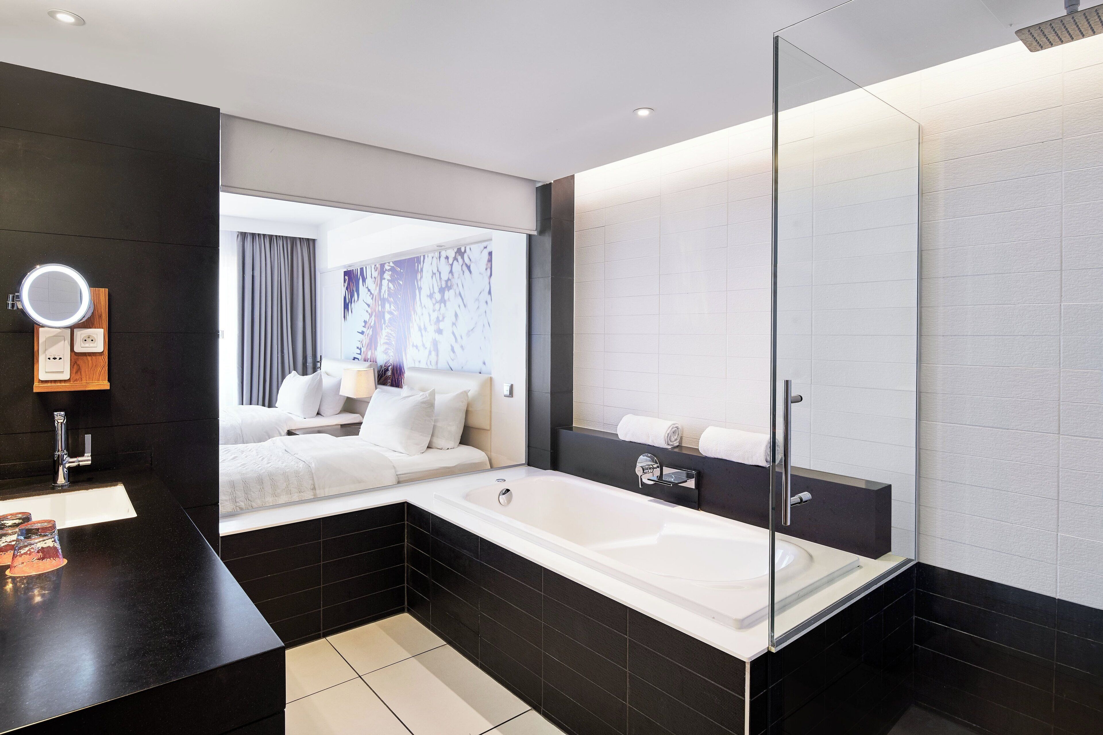 A modern bathroom with a large bathtub, a glass shower enclosure, and a vanity with a mirror.