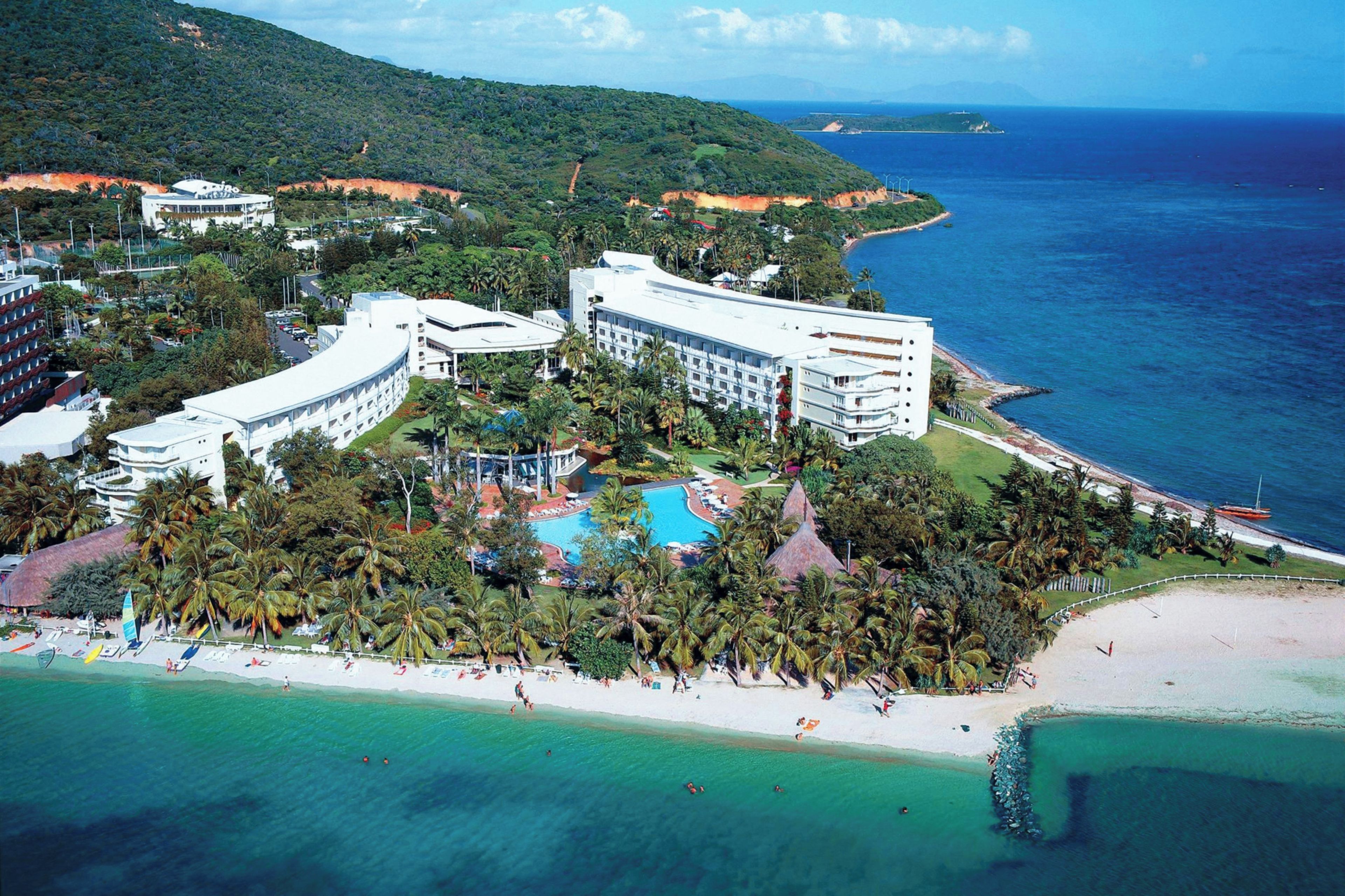 A resort with a large pool, beachfront, and multiple buildings.