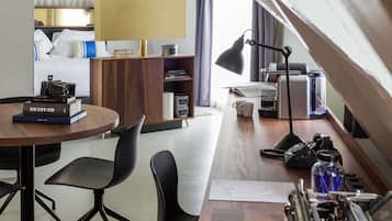 Een moderne kamer met een houten bureau, zwarte stoelen, een boekenkast, een lamp, een koffiezetapparaat en een radiator.