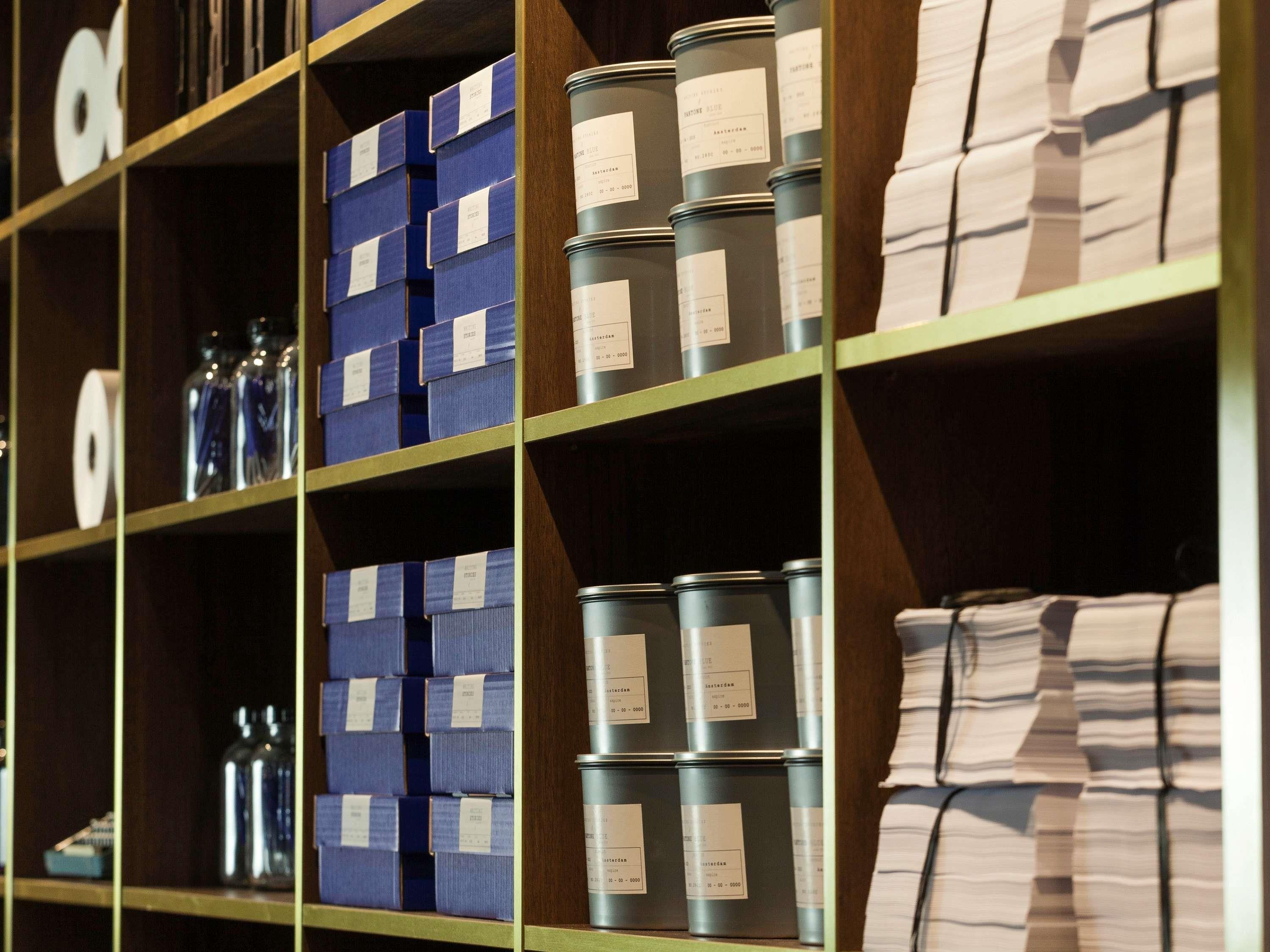 A storage area with shelves containing blue boxes and metal containers, likely for supplies or inventory.