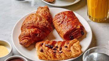En tallrik med tre croissanter och två små skålar med tillbehör.