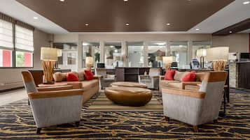 A modern lobby with sofas, a coffee station, and a reception desk.