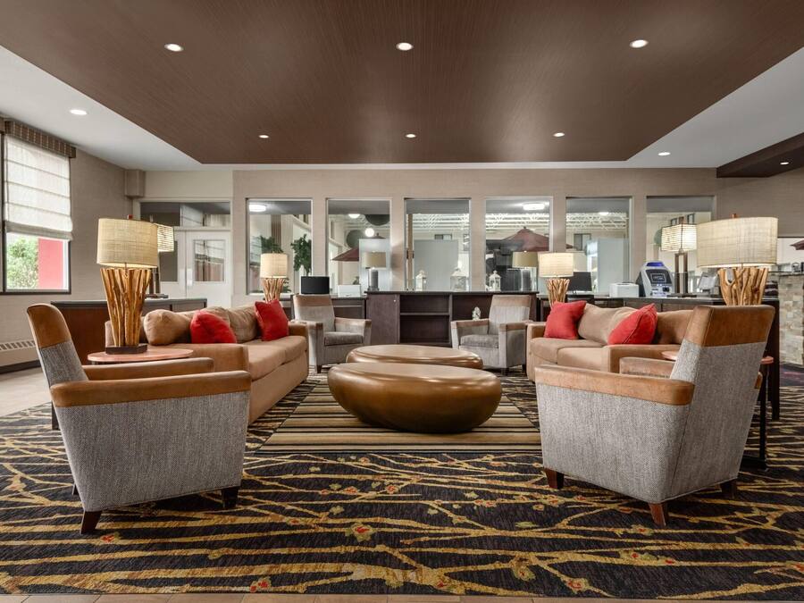 A modern lobby with sofas, a coffee station, and a reception desk.