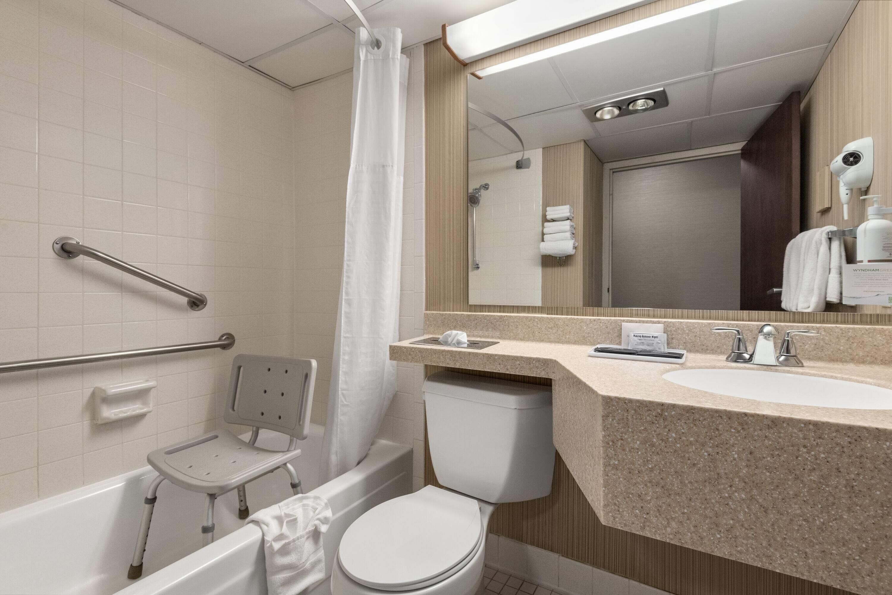 A bathroom with a bathtub, toilet, and a shower area.