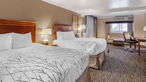 A hotel room with two beds, a desk, a chair, and a window with curtains. - Best Western Plus Landmark Inn (Park City)