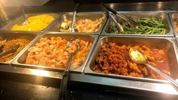 A buffet with various food options including shrimp, noodles, and vegetables.