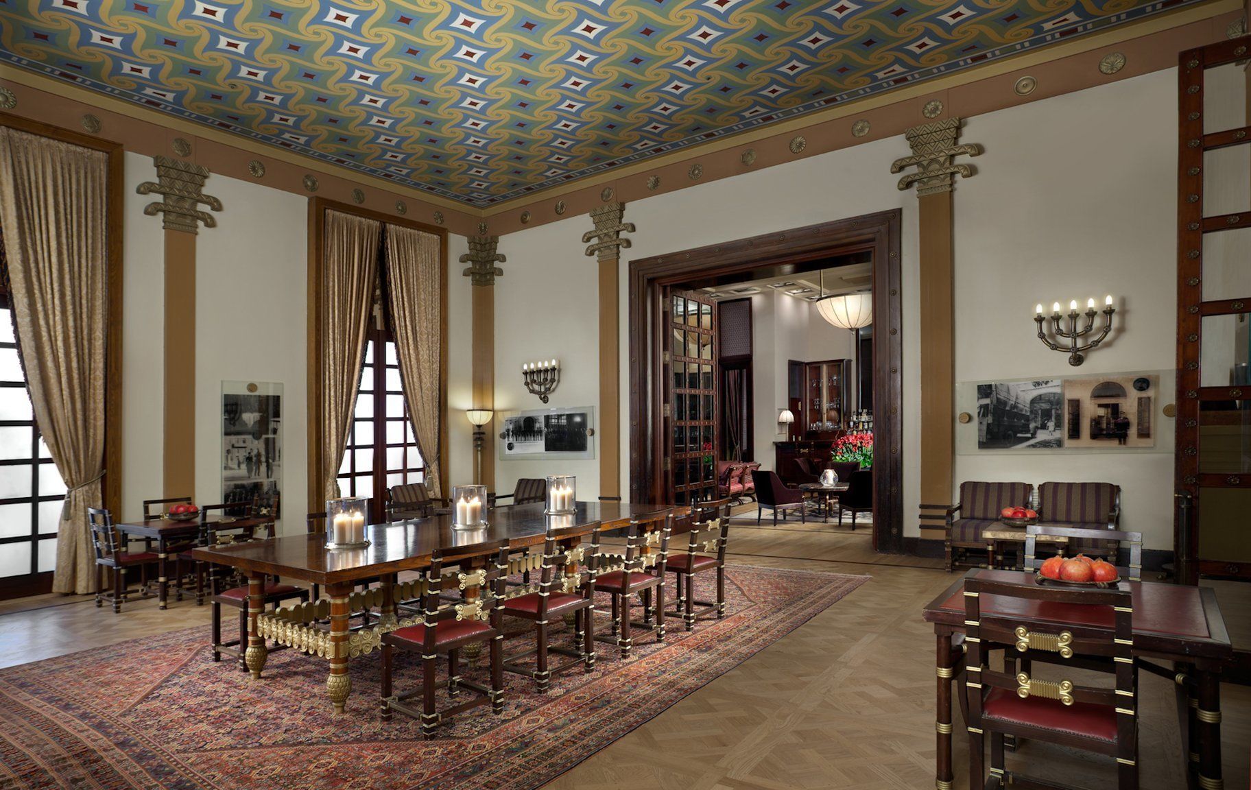 Una habitación amplia con una larga mesa de comedor, columnas decorativas y un techo con diseño.