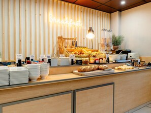 Un buffet de petit-déjeuner proposant une variété d’aliments et agrémenté d’un panneau lumineux au néon.