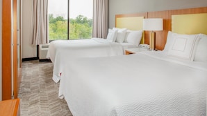 A hotel room with two beds, a wooden headboard, a bedside table with a lamp, and a large window with curtains. - SpringHill Suites Cincinnati North/Forest Park (Cincinnati)