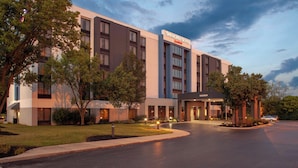 A modern hotel with a large sign reading "Springhill Suites." It features a spacious entrance, well-maintained landscaping, and a parking area. - SpringHill Suites Cincinnati North/Forest Park (Cincinnati)