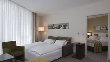 Une chambre d’hôtel avec un lit, une chaise, une table de chevet, une lampe et un tableau au mur.