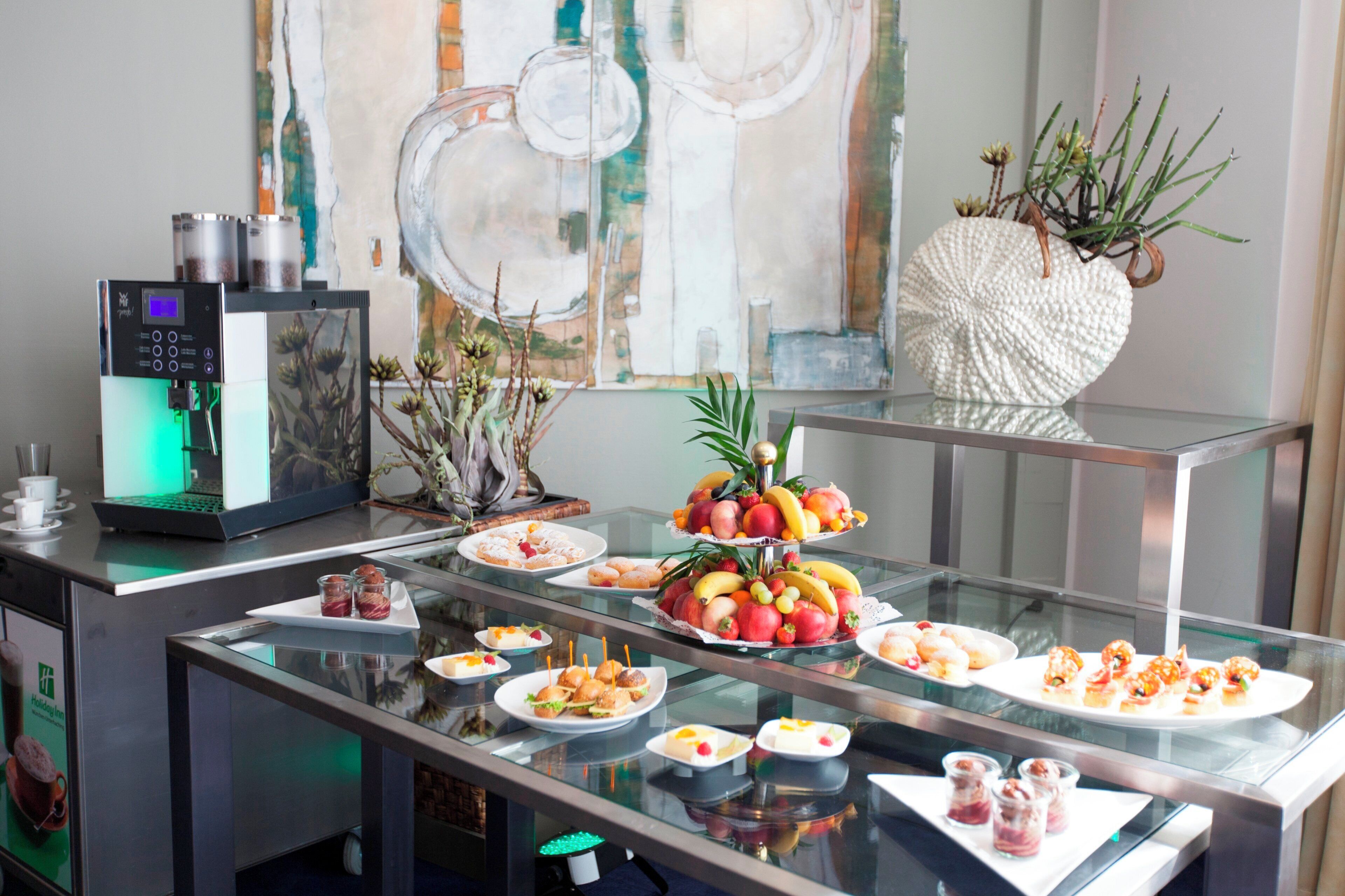 A buffet setup with various food items and a coffee machine.