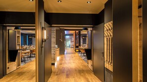 A hotel corridor with wooden flooring, a reception desk, and a dining area with tables and chairs. - Holiday Inn Munich-Unterhaching by IHG (Unterhaching)