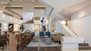 A spacious, modern interior with a central seating area, a staircase, and a high ceiling with recessed lighting. - Cassia Hotel Jerusalem (Jerusalem)