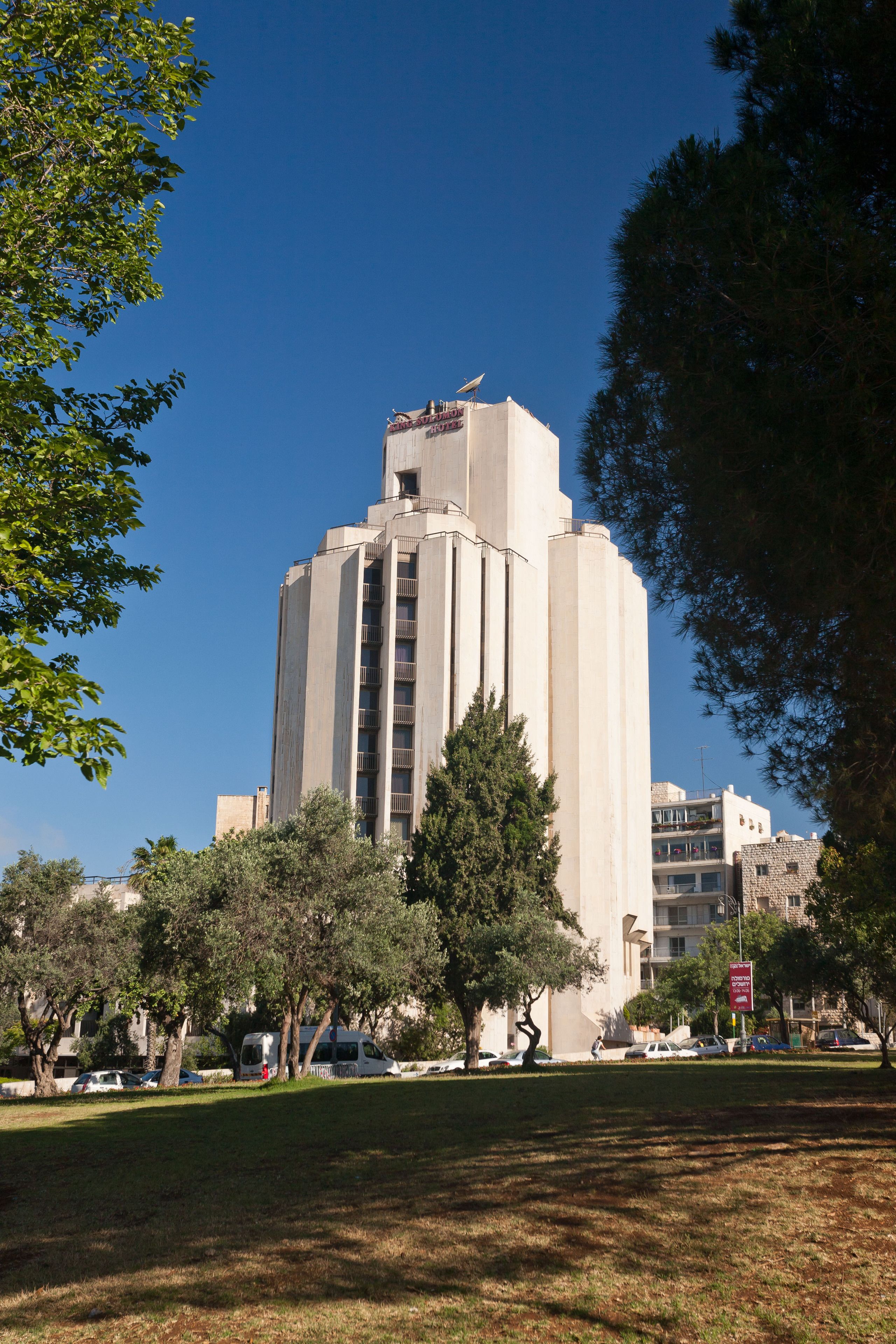 A tall, modern building with a flat roof and a central entrance.