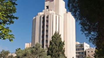 A tall, modern building with a flat roof and a central entrance.
