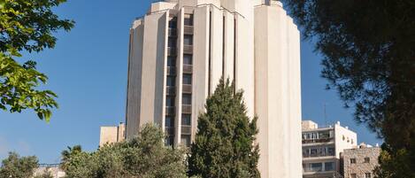 A tall, modern building with a flat roof and a central entrance.