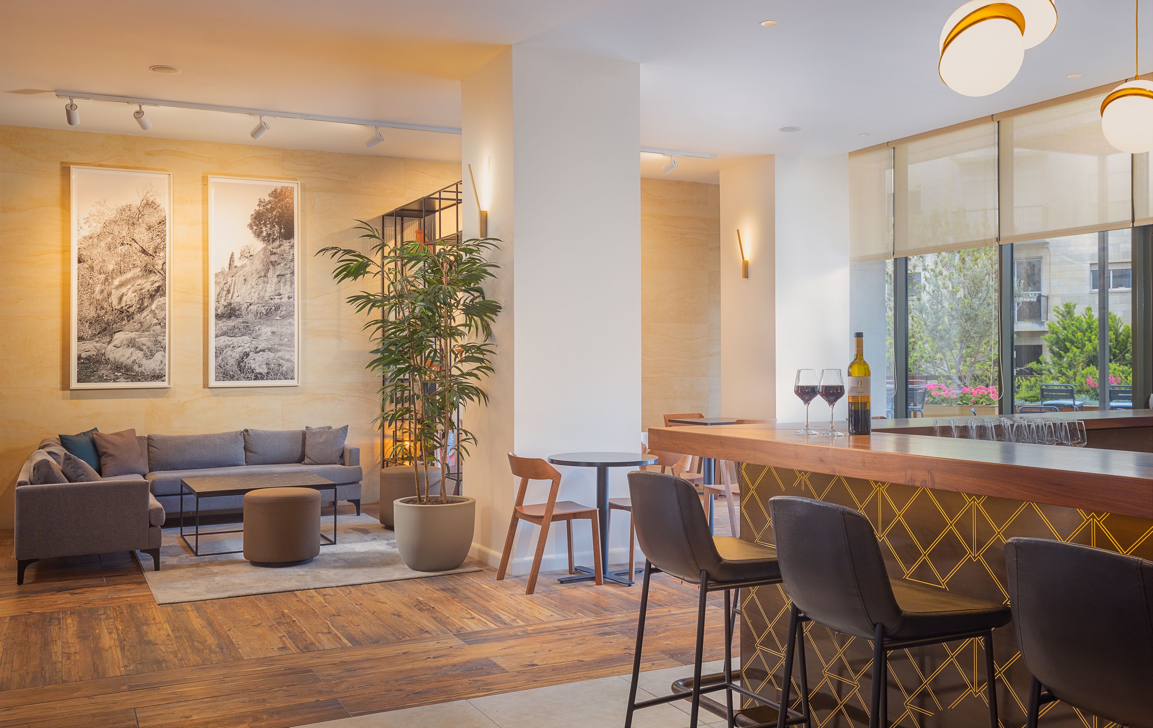 A modern interior with a sofa, chairs, a bar area, and artwork on the walls.