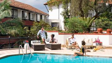 Alberca al aire libre, sombrillas en la alberca y camastros