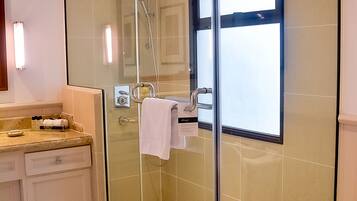 A modern bathroom with a glass-enclosed shower, a vanity with a mirror, and a toilet.