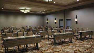 A conference room with multiple tables and chairs, equipped with water bottles and nameplates.