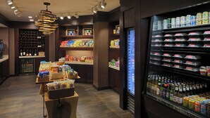 A well-lit store with shelves stocked with snacks, beverages, and bottled water.