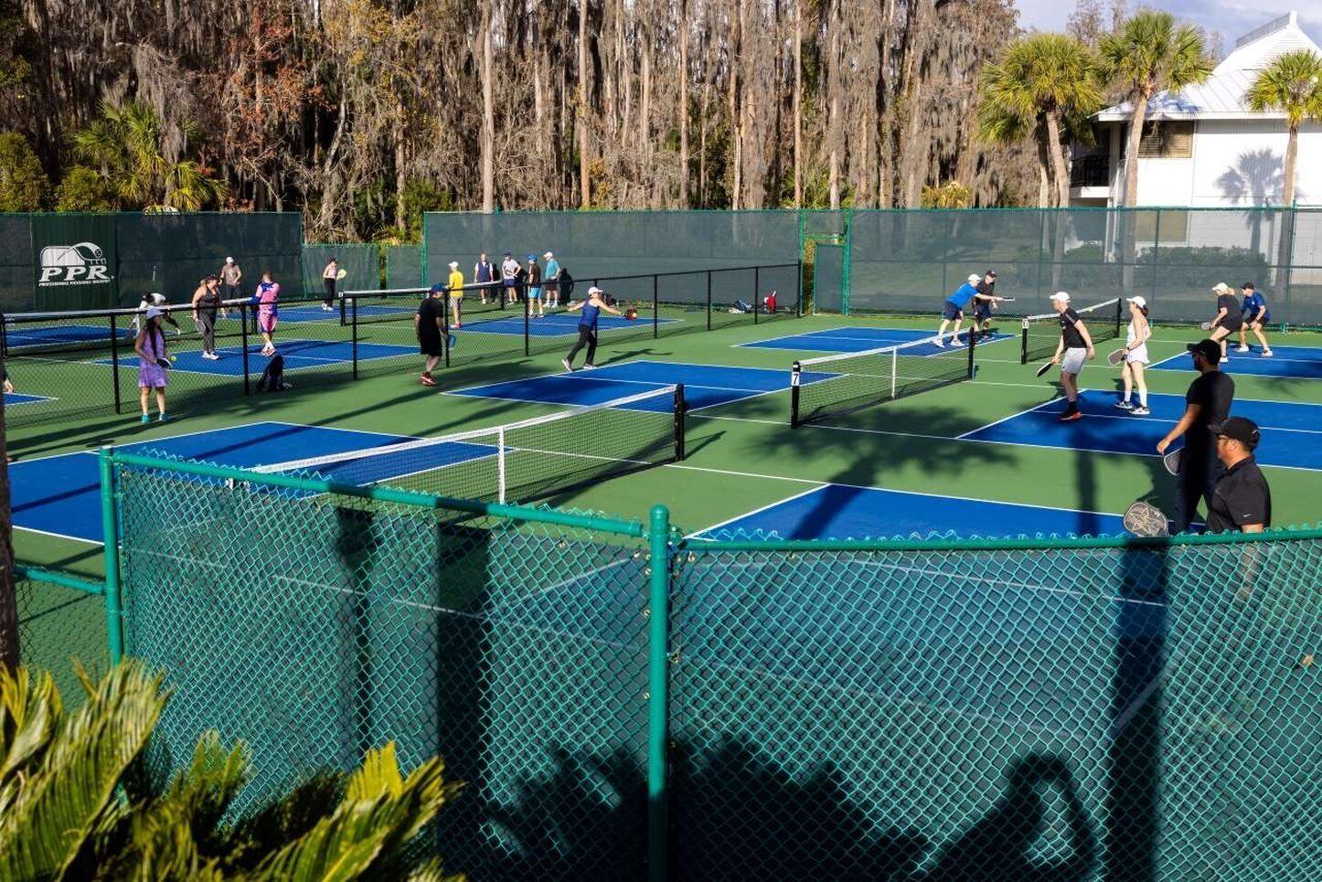A tennis court with multiple players and a net in the center.