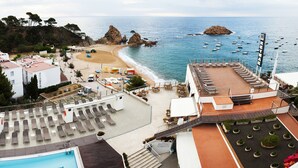 A beachside hotel with a pool, sun loungers, and a view of the sea. - Gran Hotel Reymar (Tossa de Mar)