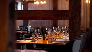 Un restaurante con mesas dispuestas para comer, con vigas de madera y un ambiente cálido.