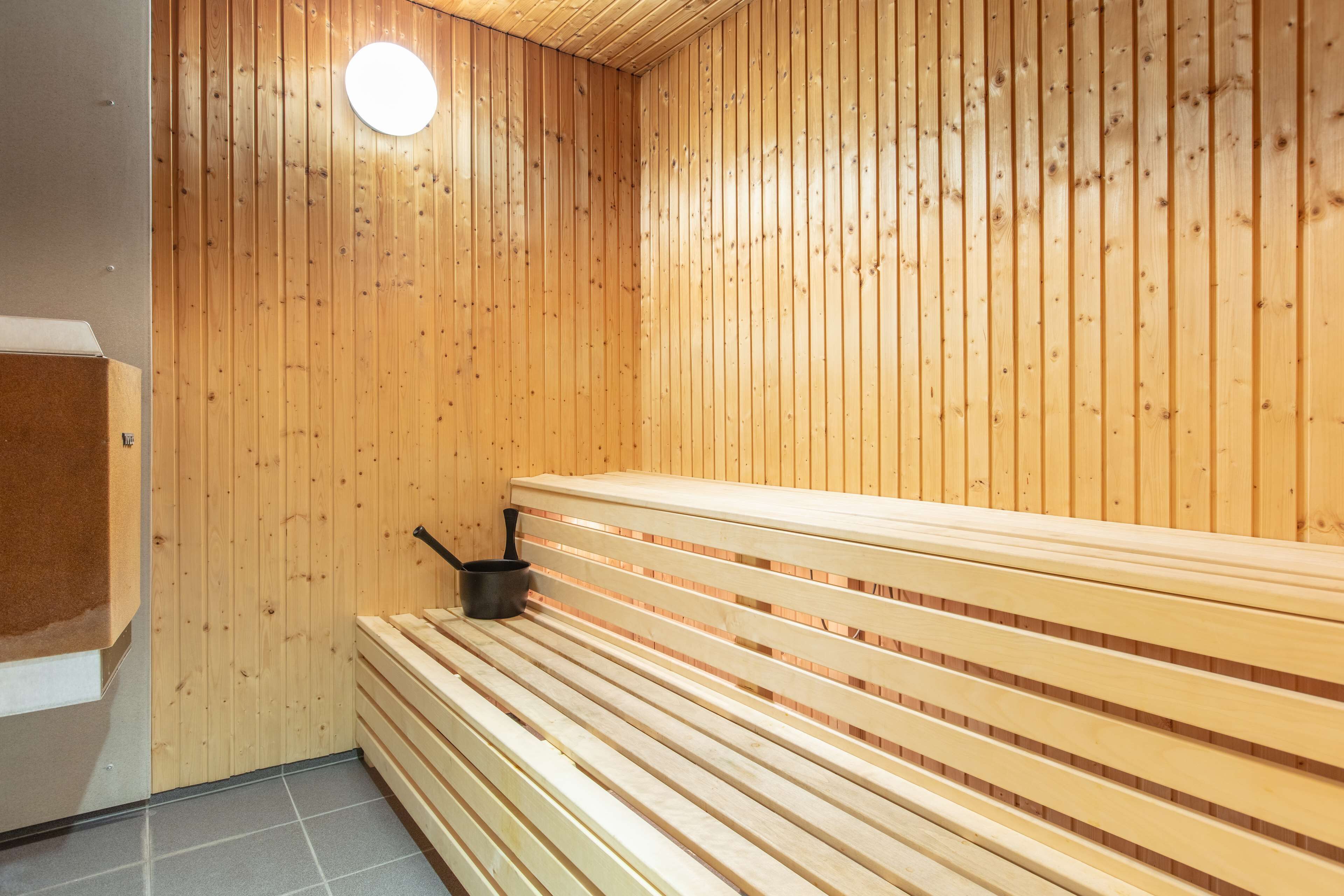 A sauna with wooden benches and a small heater.